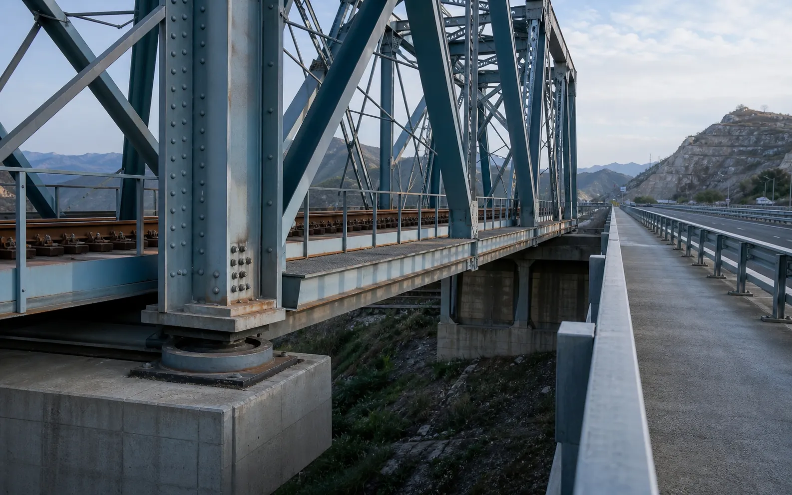 Steel bridge carrying rail and road transport with structural connection and bearing zones visible