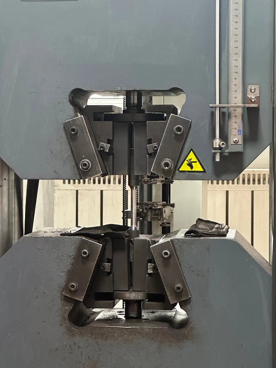 A tensile specimen held in the grips of a testing machine