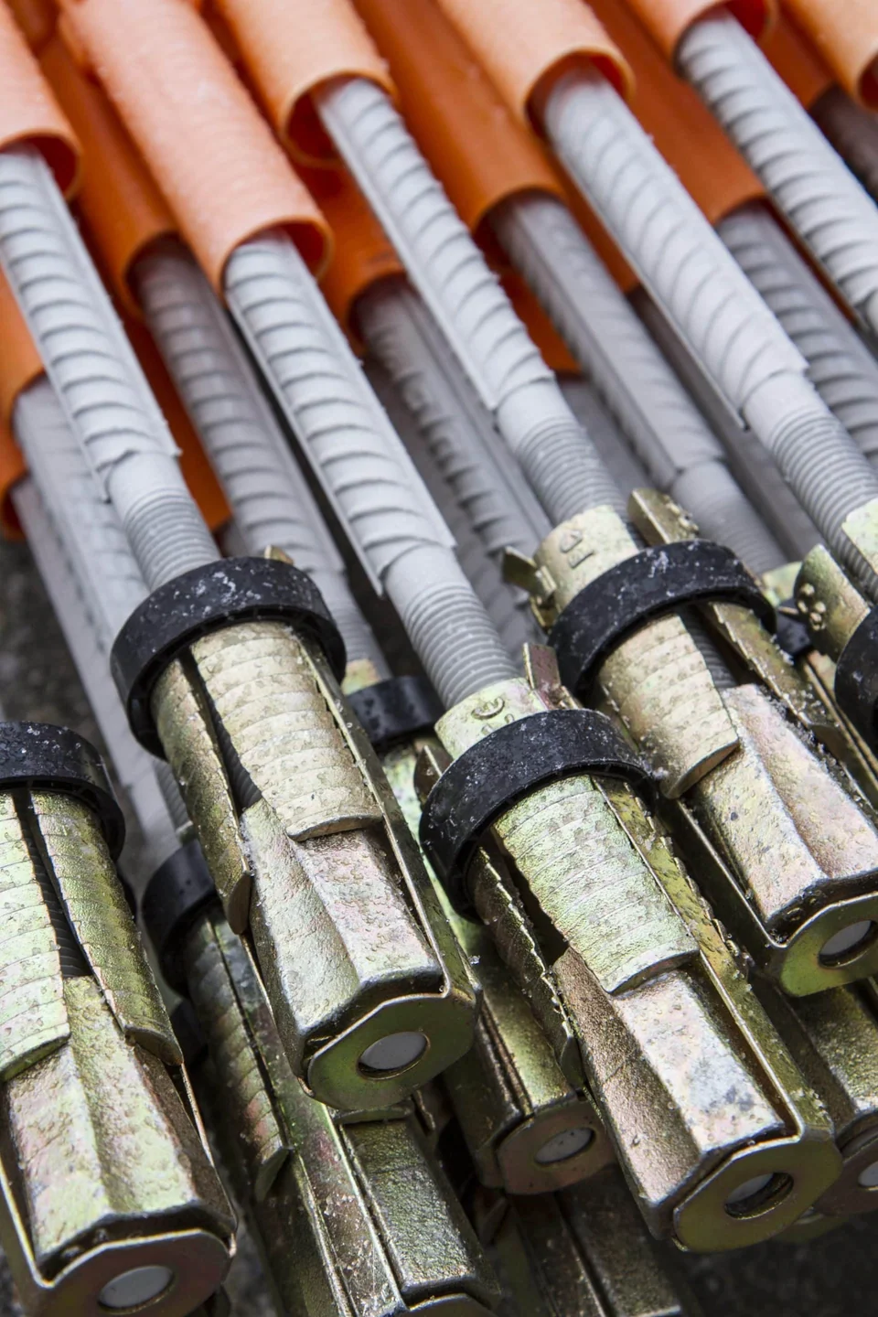 Manufacturer photograph of steel combination-bolt expansion heads, threaded rods and protective sleeves