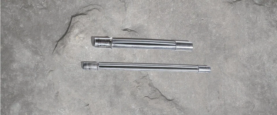 Manufacturer photograph of formed expandable steel rock-bolt tubes and end fittings