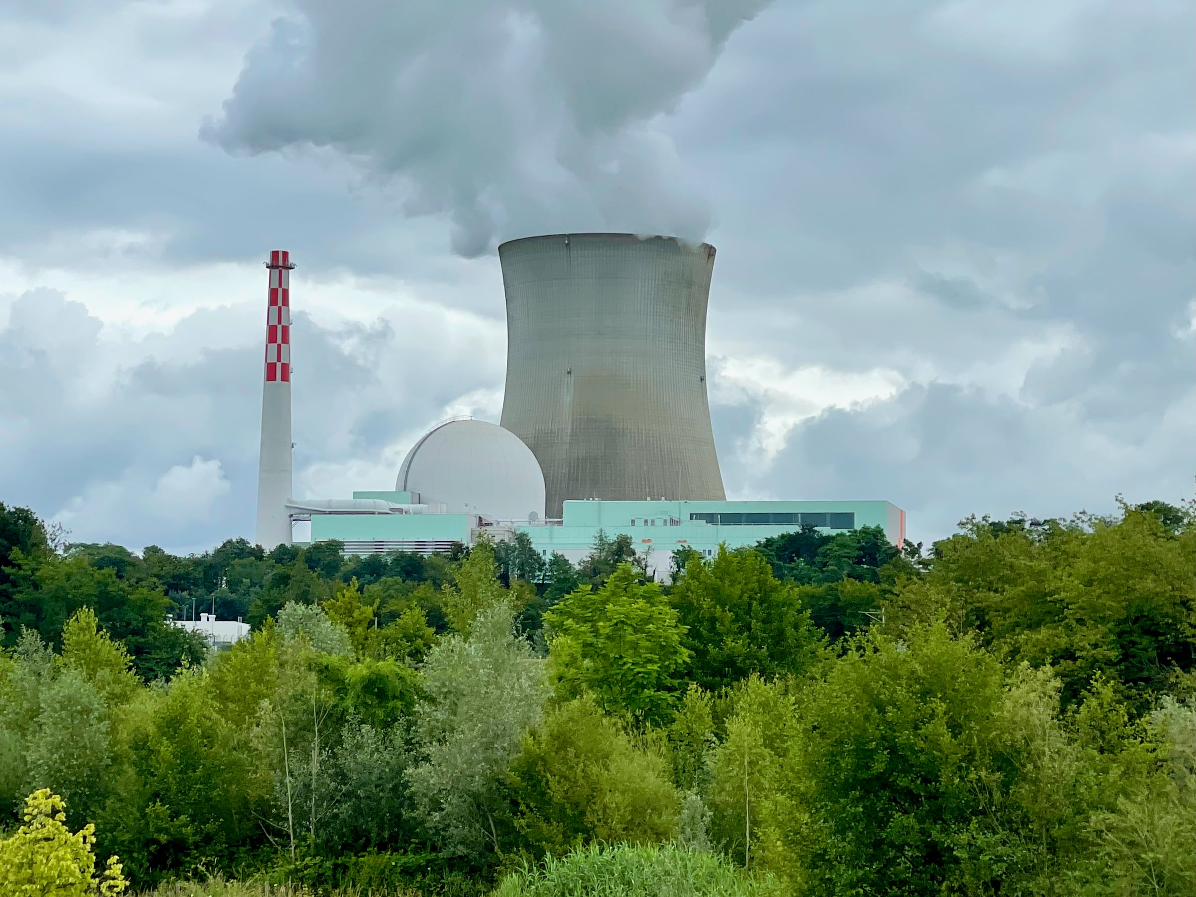 Nuclear power station with a visible reactor containment dome and cooling tower