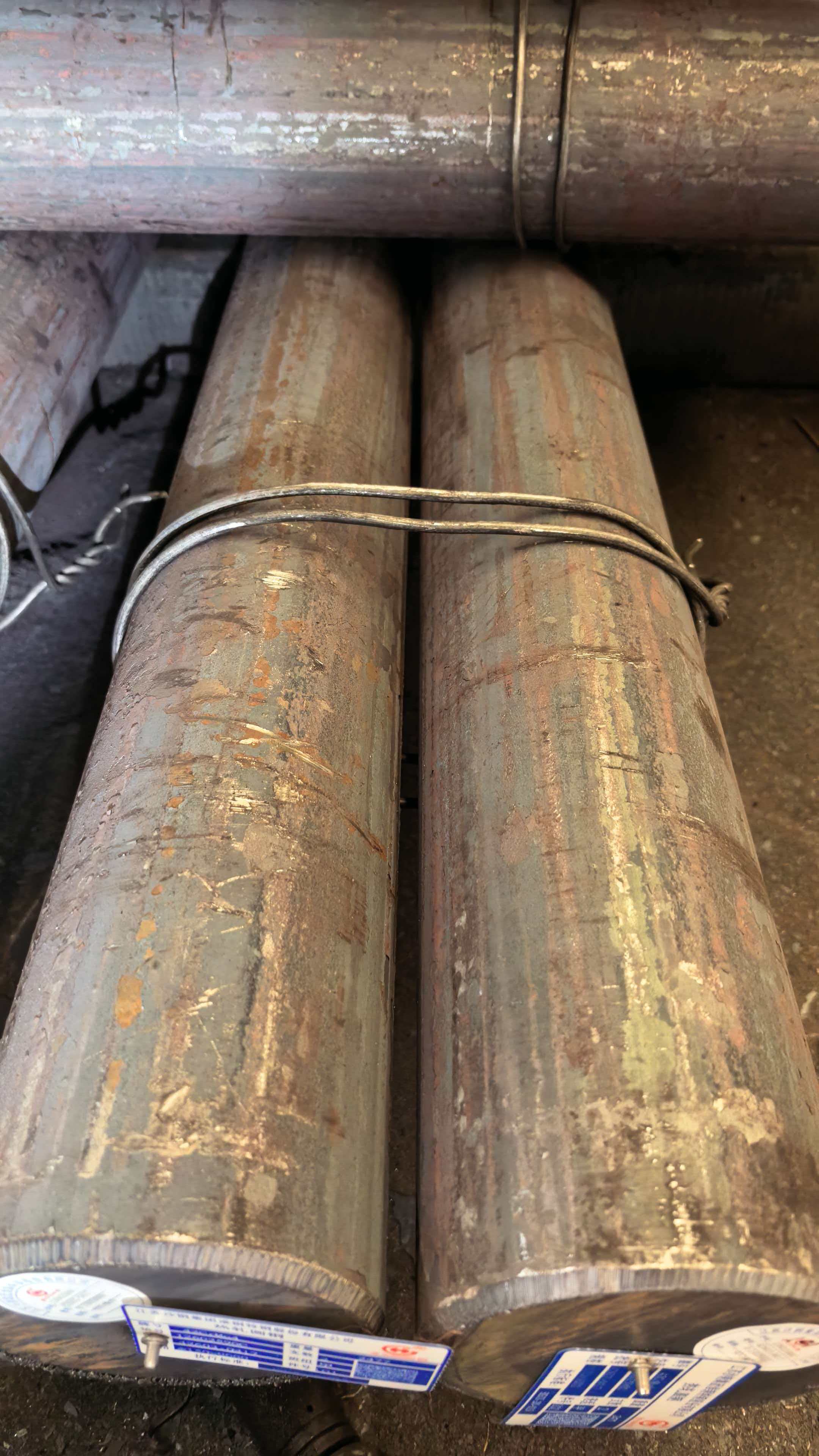 Close view of long round steel bars in industrial storage