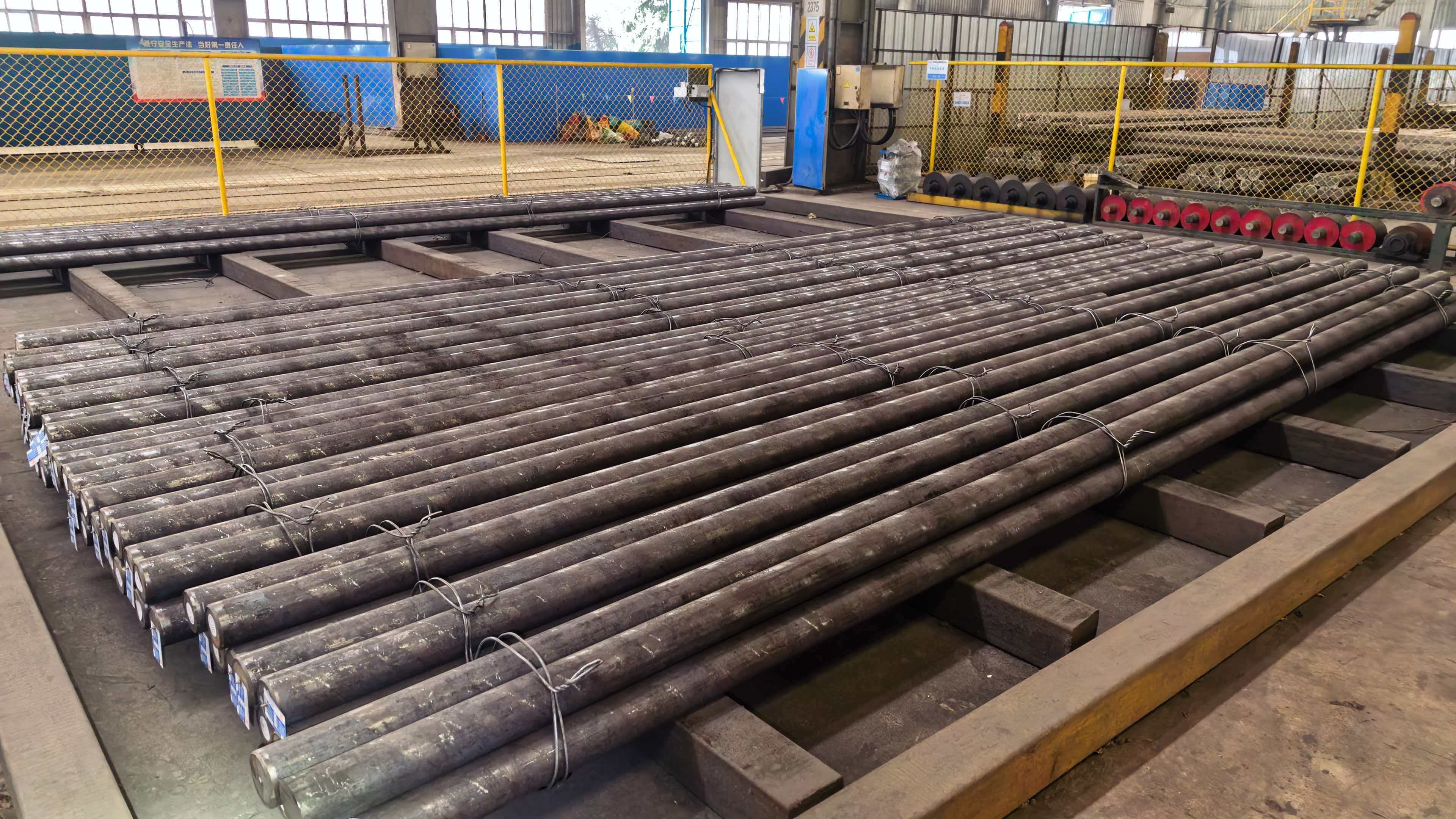Rows of long round steel bars prepared in warehouse storage