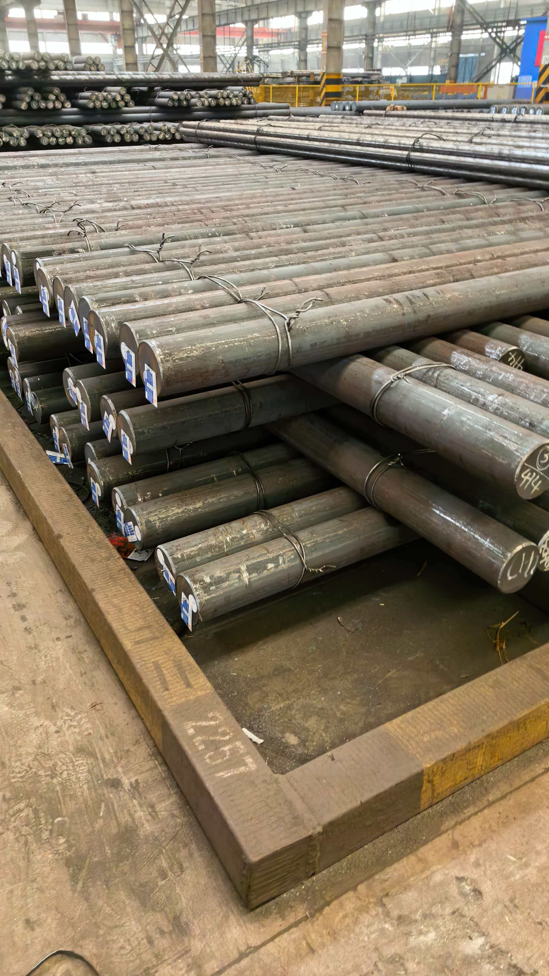 Stacked long round steel bars in industrial storage