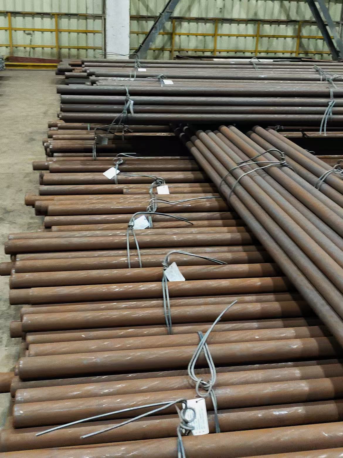 Tagged bundles of long round steel bars arranged in a warehouse