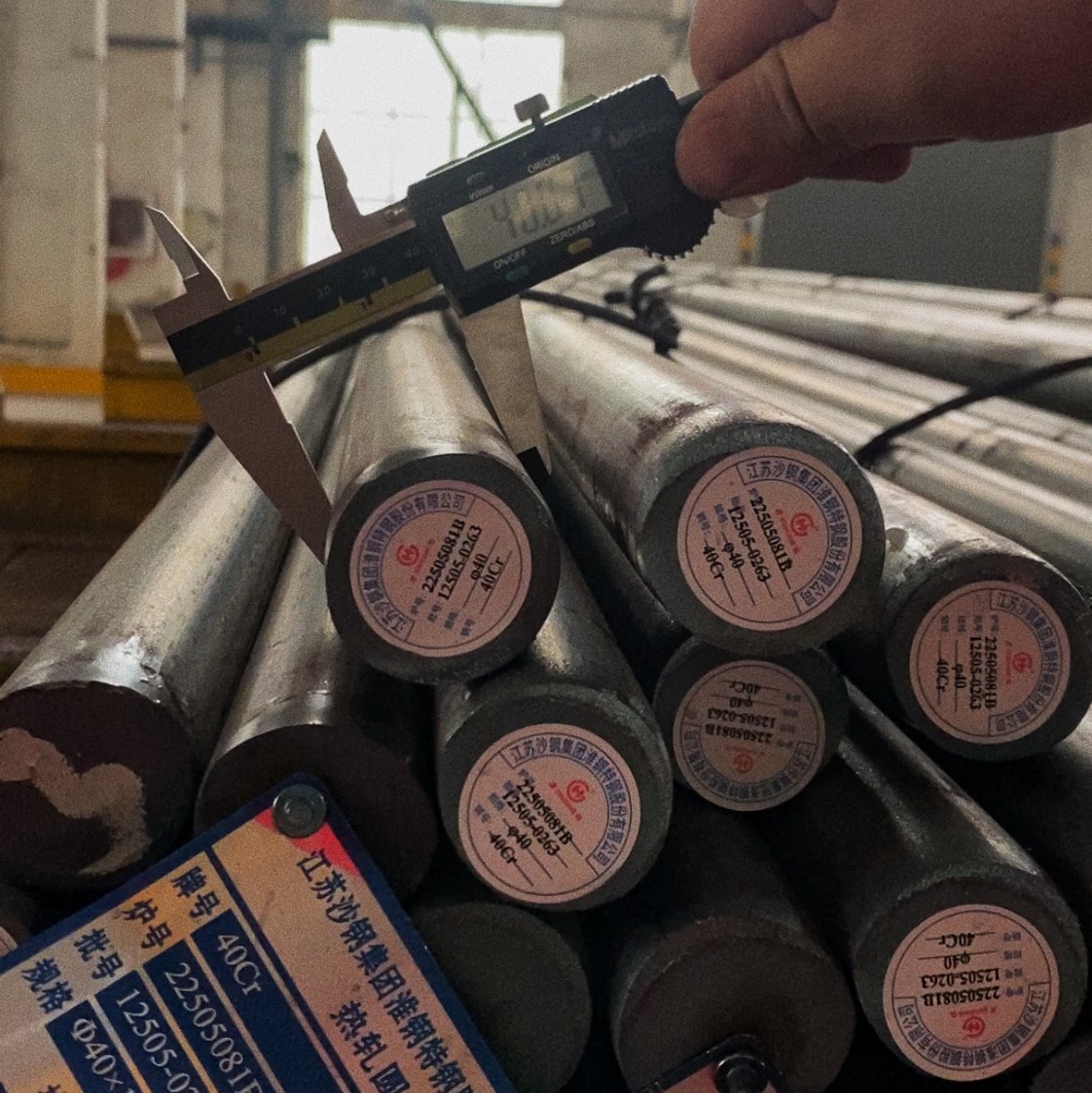 Digital caliper measuring the ends of tagged round steel bars